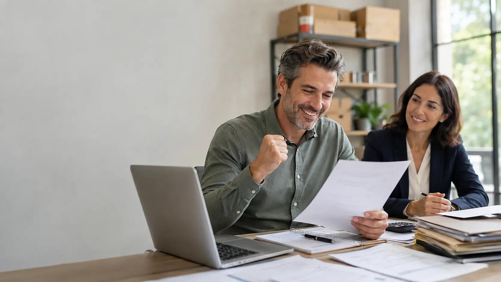 Autónomo sonriente revisando documentos con una asesora, representando alivio y recuperación económica gracias a la Ley de Segunda Oportunidad.